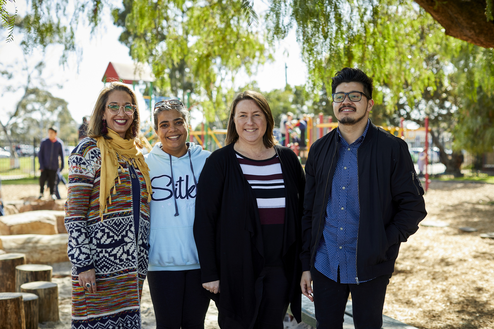 A group of adults standing outside, smiling at the camera.