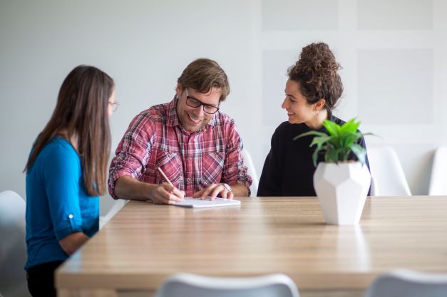 Three adults working together around a table