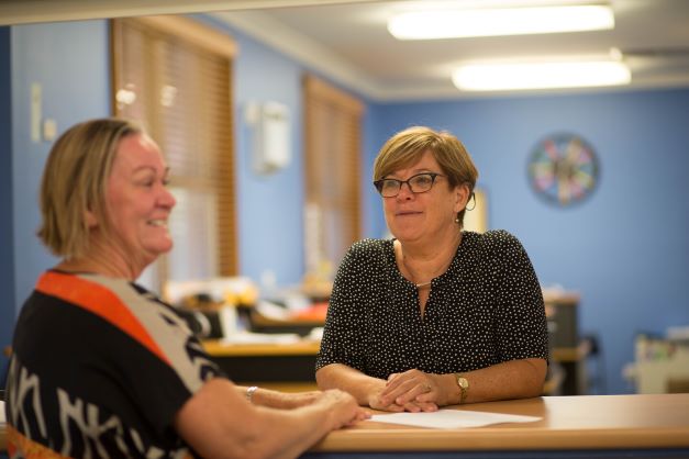 Two adults speaking in a reception area