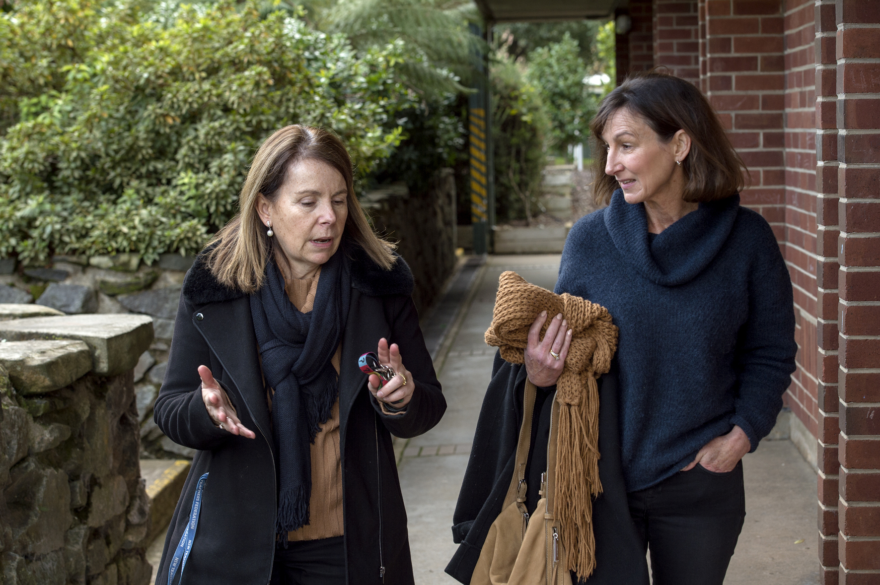 Two adults, walking outside a school