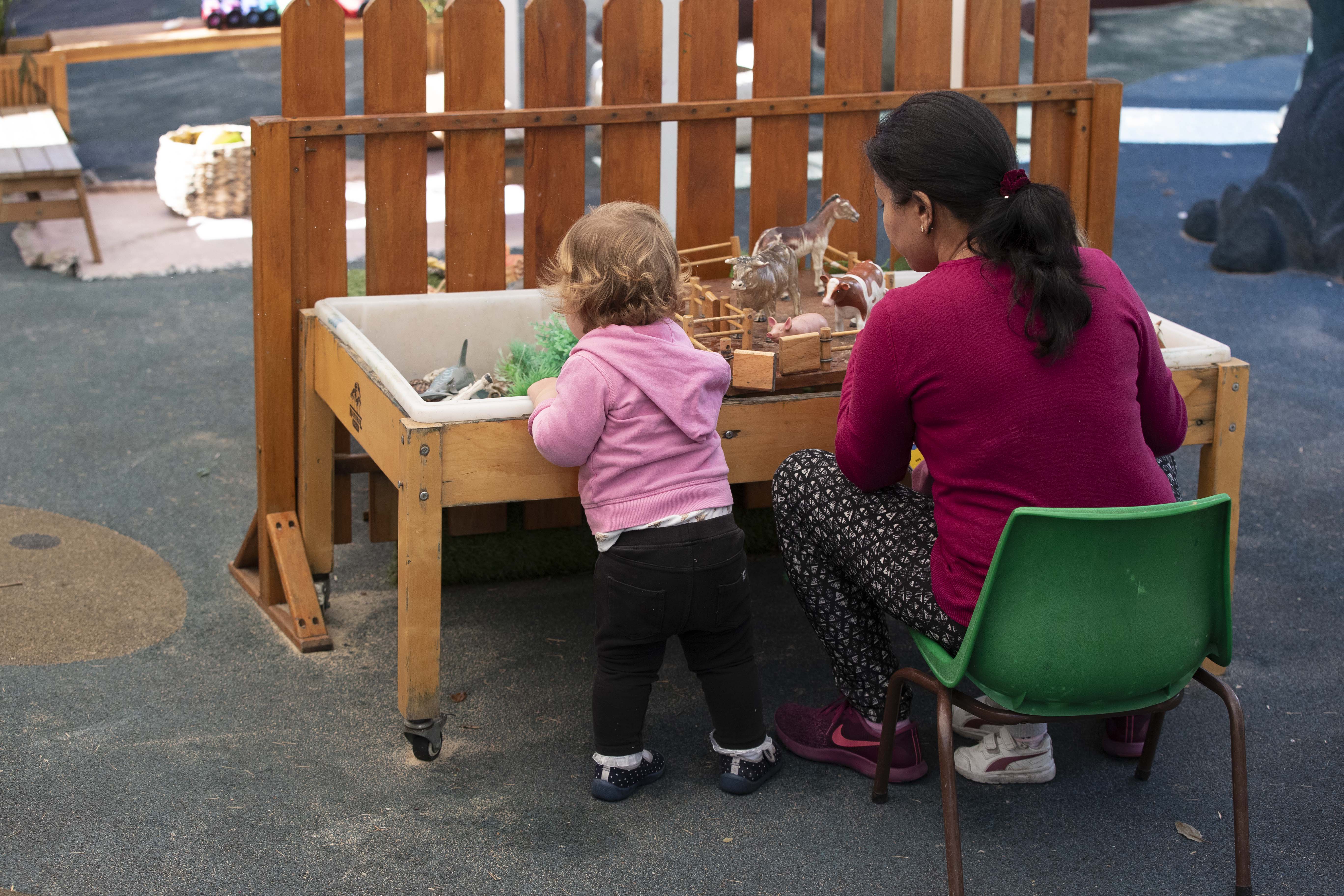 An educator and toddler playing together