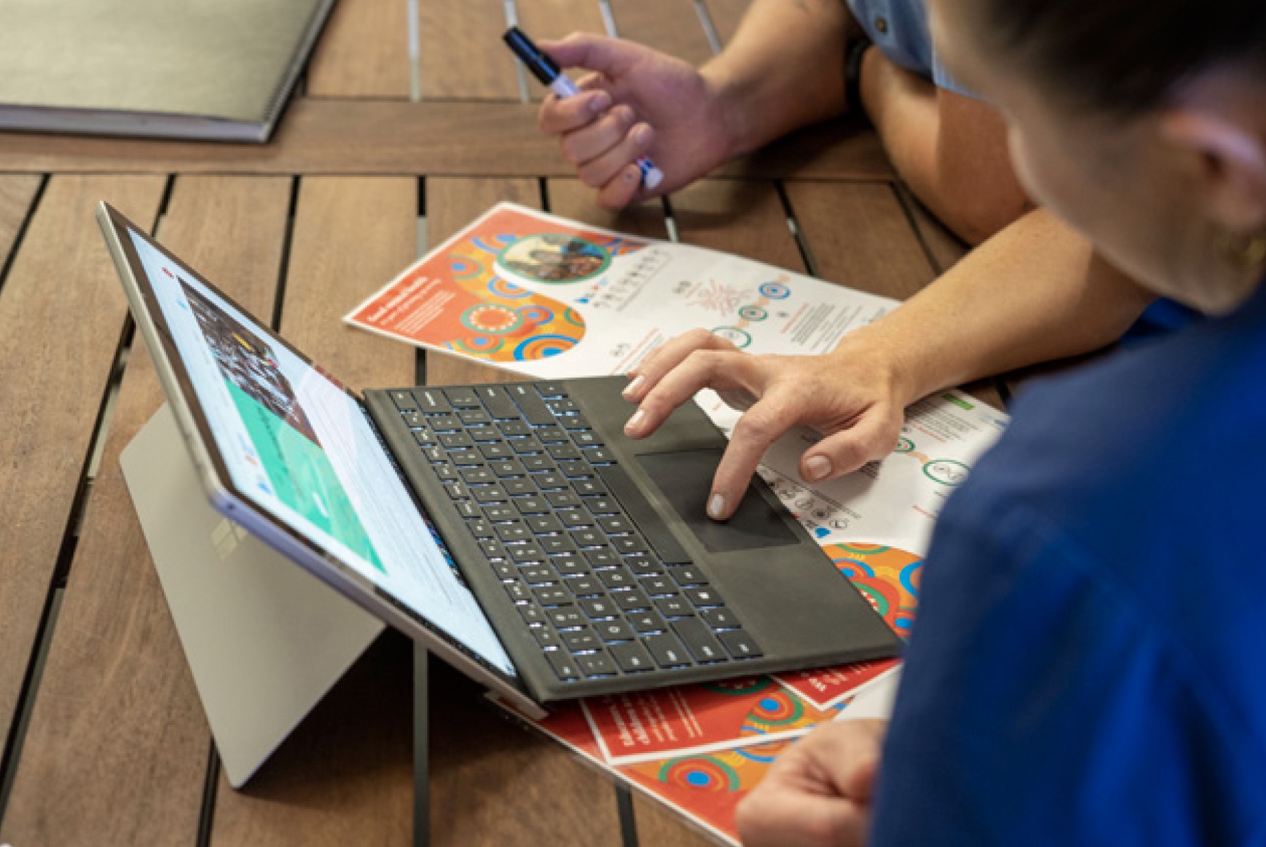 People gathering around a laptop